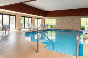 una piscina en una habitación de hotel con sillas y mesas en Hampton Inn Milwaukee Northwest, en Milwaukee