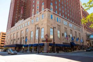 a large building on a city street with cars parked in front at Hilton Milwaukee City Center in Milwaukee