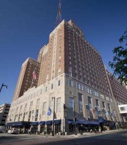 a tall building on a city street with a blue sky at Hilton Milwaukee City Center in Milwaukee