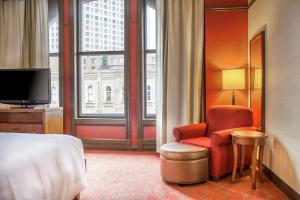 a hotel room with a bed and a chair and a television at Hilton Garden Inn Milwaukee Downtown in Milwaukee