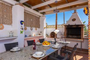een buitenkeuken met een tafel en een pizza-oven bij Villa Alta Vista in Frigiliana