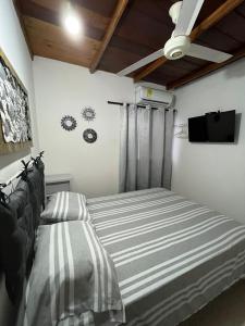 1 dormitorio con 1 cama y TV de pantalla plana en Casa 39-33, en Cartagena de Indias