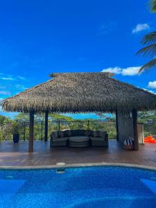a resort with a couch and a thatch roof at Iro Luxury Retreat in Rarotonga