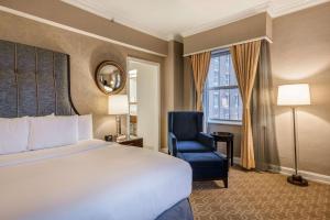 a hotel room with a bed and a chair and a window at Hilton Milwaukee City Center in Milwaukee