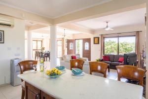 a kitchen and living room with a table and chairs at Villa Dora in Argaka