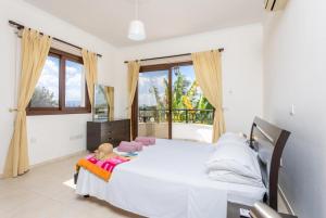 a bedroom with a large white bed and a window at Villa Dora in Argaka +36 photos