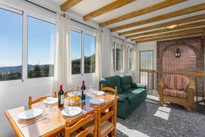 a living room with a table and a green couch at Villa Casa Leo in Frigiliana