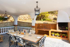 a dining room with a table and a fireplace at Villa Casa Leo in Frigiliana