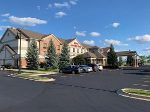 a large building with cars parked in a parking lot at Hilton Garden Inn Oconomowoc in Oconomowoc