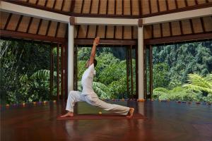 a woman doing a yoga pose in a room at Bagus Jati Health & Wellbeing Retreat in Tegalalang