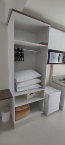 a white closet with a shelf with towels at SPAZZIO Andrian & Silva - INCLUSOS INGRESSOS DO PARQUE in Caldas Novas