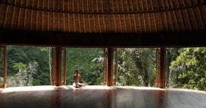 a person sitting in a room looking out of a window at Bagus Jati Health & Wellbeing Retreat in Tegalalang