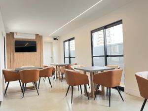 a conference room with tables and chairs and windows at Start - Vila Izabel in Curitiba