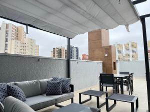 a couch on a rooftop with a table and chairs at Start - Vila Izabel in Curitiba