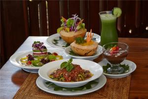 a table with plates of food and a drink at Bagus Jati Health & Wellbeing Retreat in Tegalalang