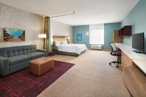 une chambre d'hôtel avec un lit et un canapé dans l'établissement Home2 Suites By Hilton Palm Bay I 95, à Melbourne