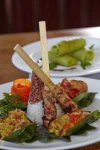 a plate of food with meat and rice on a table at Bagus Jati Health & Wellbeing Retreat in Tegalalang