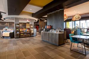 a restaurant with a counter and chairs and tables at Tru By Hilton Manassas, Va in Manassas