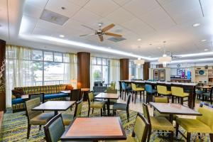 a dining room with tables and chairs and windows at Hampton Inn Mobile/East Bay in Daphne