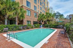 une piscine avec des chaises et un bâtiment dans l'établissement Homewood Suites Mobile East Bay/Daphne, à Daphne