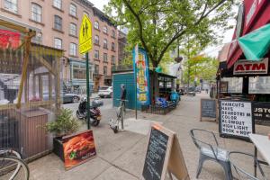 une rue urbaine avec des bâtiments et un trottoir avec des panneaux dans l'établissement Stylish 2Bd in Brooklyn Heights, à Brooklyn