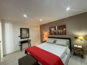 una camera da letto con un grande letto con una coperta rossa di Attico nell' entroterra salentino a Casarano