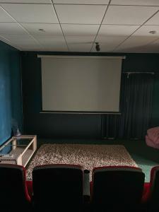 a projection screen in a room with chairs at Iro Luxury Retreat in Rarotonga