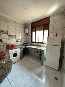 Sidi Youssef Agadir في أغادير: مطبخ مع ثلاجة بيضاء وغسالة صحون