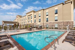 a pool at a hotel with chairs and a building at Hampton Inn by Hilton Turlock in Turlock