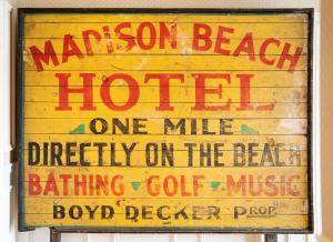 a sign for apotion beach hotel one miledirectivity on the beachbow detector at Madison Beach Hotel, Curio Collection by Hilton in Madison