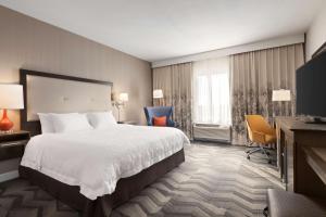 een hotelkamer met een bed, een bureau en stoelen bij Hampton Inn by Hilton Turlock in Turlock