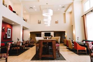 a dining room with tables and chairs and a chandelier at Hampton Inn & Suites Minot in Minot