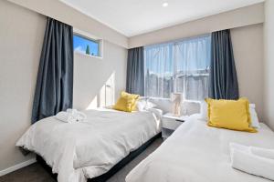 two beds in a room with a window at Top Spot Rotorua in Rotorua