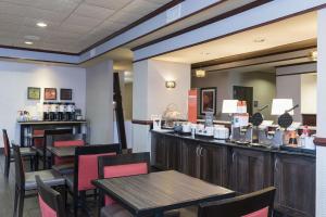 a restaurant with a bar with tables and chairs at Hampton Inn Mount Pleasant in Mount Pleasant