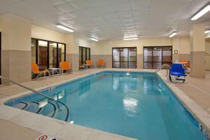 a swimming pool in a hotel room with orange chairs at Hampton Inn & Suites Nashville-Smyrna in Smyrna