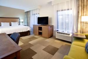 a hotel room with a bed and a flat screen tv at Hampton Inn & Suites Nashville-Smyrna in Smyrna