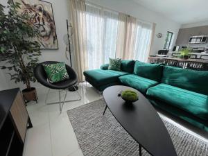 sala de estar con sofá verde y mesa en ! Espectacular casa del bosque !, en Florida City