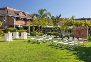 een groep witte tafels en stoelen op een gazon bij Seacliff Inn Aptos, Tapestry Collection by Hilton in Aptos