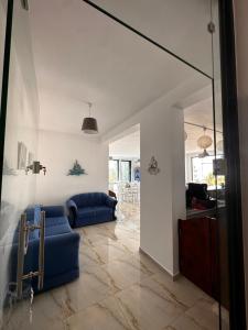 a living room with a blue couch and a glass door at Hotel Belle Vue in Ksamil