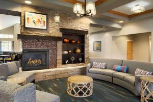 uma sala de estar com sofás e uma lareira em Homewood Suites by Hilton Madison West em Madison