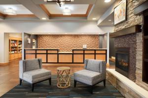 a lobby with two chairs and a fireplace at Homewood Suites by Hilton Madison West in Madison