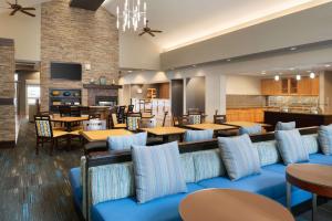 a lobby with blue couches and tables and a restaurant at Homewood Suites by Hilton Madison West in Madison