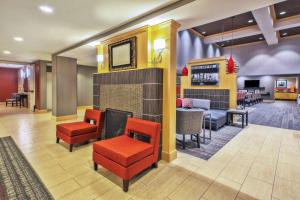 a lobby of a hotel with red chairs and a bar at Hampton Inn & Suites Madison - West in Madison