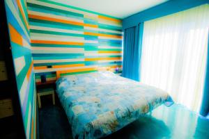 1 dormitorio con una pared colorida y 1 cama en Aurelia Beach, private pool, Santa Marinella, Rome, en Santa Marinella