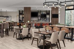 ein Restaurant mit Tischen und Stühlen und eine Bar in der Unterkunft Hilton Garden Inn Minneapolis Downtown in Minneapolis