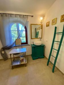 La salle de bains est pourvue d'un lavabo vert et d'une échelle. dans l'établissement Casale Il Tiglio, à Anghiari