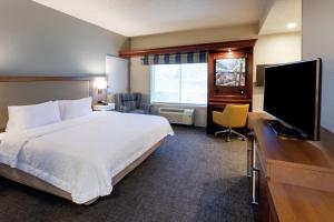 a hotel room with a bed and a flat screen tv at Hampton Inn Minneapolis/Eagan in Eagan