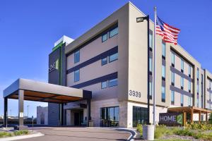 イーガンにあるHome2 Suites By Hilton Eagan Minneapolisの前面にアメリカ旗を掲げた建物