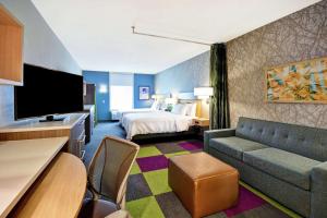 une chambre d'hôtel avec un lit et un canapé dans l'établissement Home2 Suites By Hilton Eagan Minneapolis, à Eagan