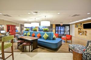 a lobby with a blue couch and a table and chairs at Home2 Suites By Hilton Minneapolis-Eden Prairie in Minnetonka